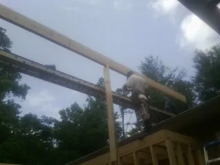 Carpenter setting a ridge beam over a new addition frame — Ice Dam Removal by Roofing Brothers in San Jose