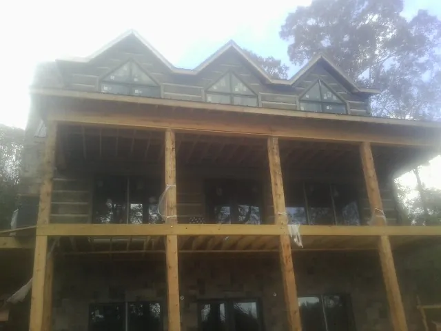 Dormers and porch framing on a large log home under construction — Roof Coating work by our crew in San Jose