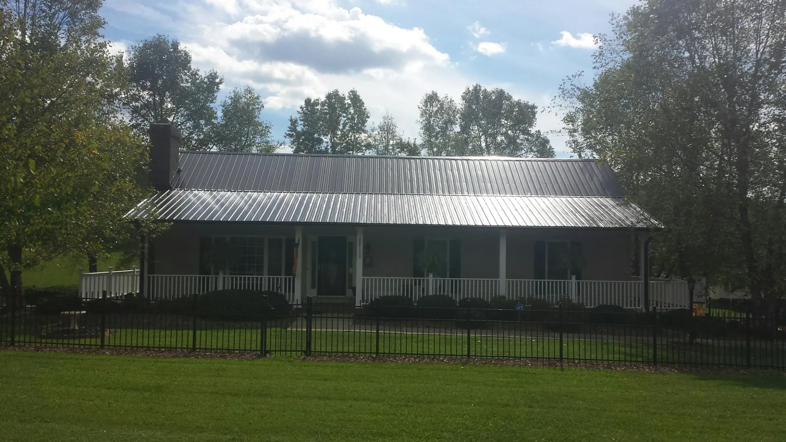 Gray metal roof on a brick ranch with a full width front porch — Gutter Guard Installation work by our crew in San Jose